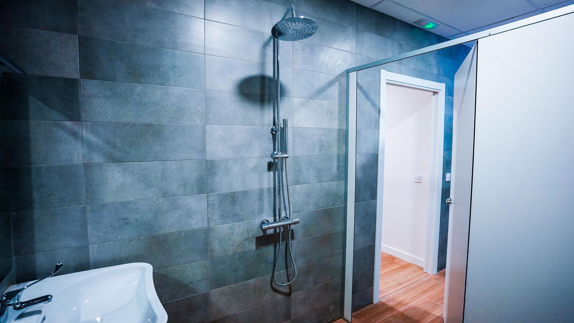 Un baño con ducha, lavabo y puerta.