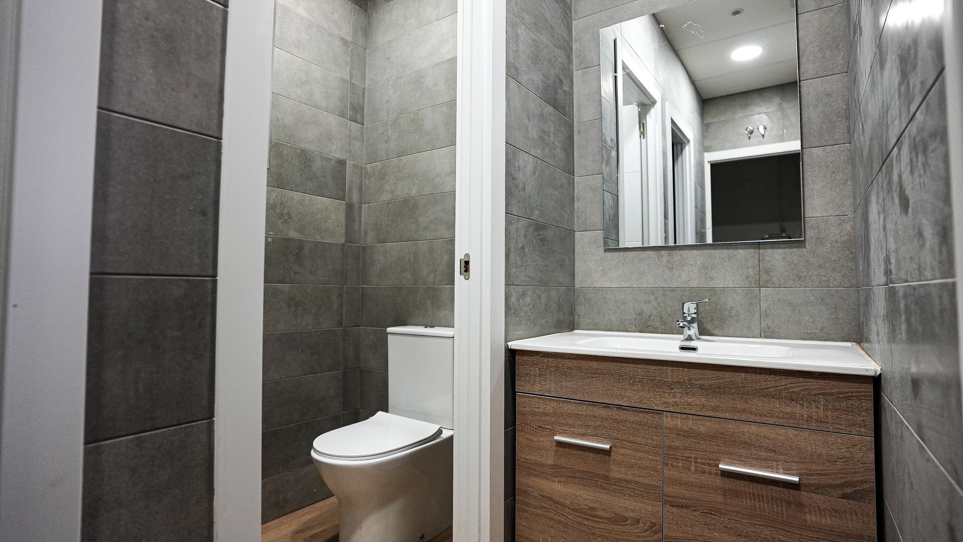 Un baño con inodoro, lavabo y espejo.