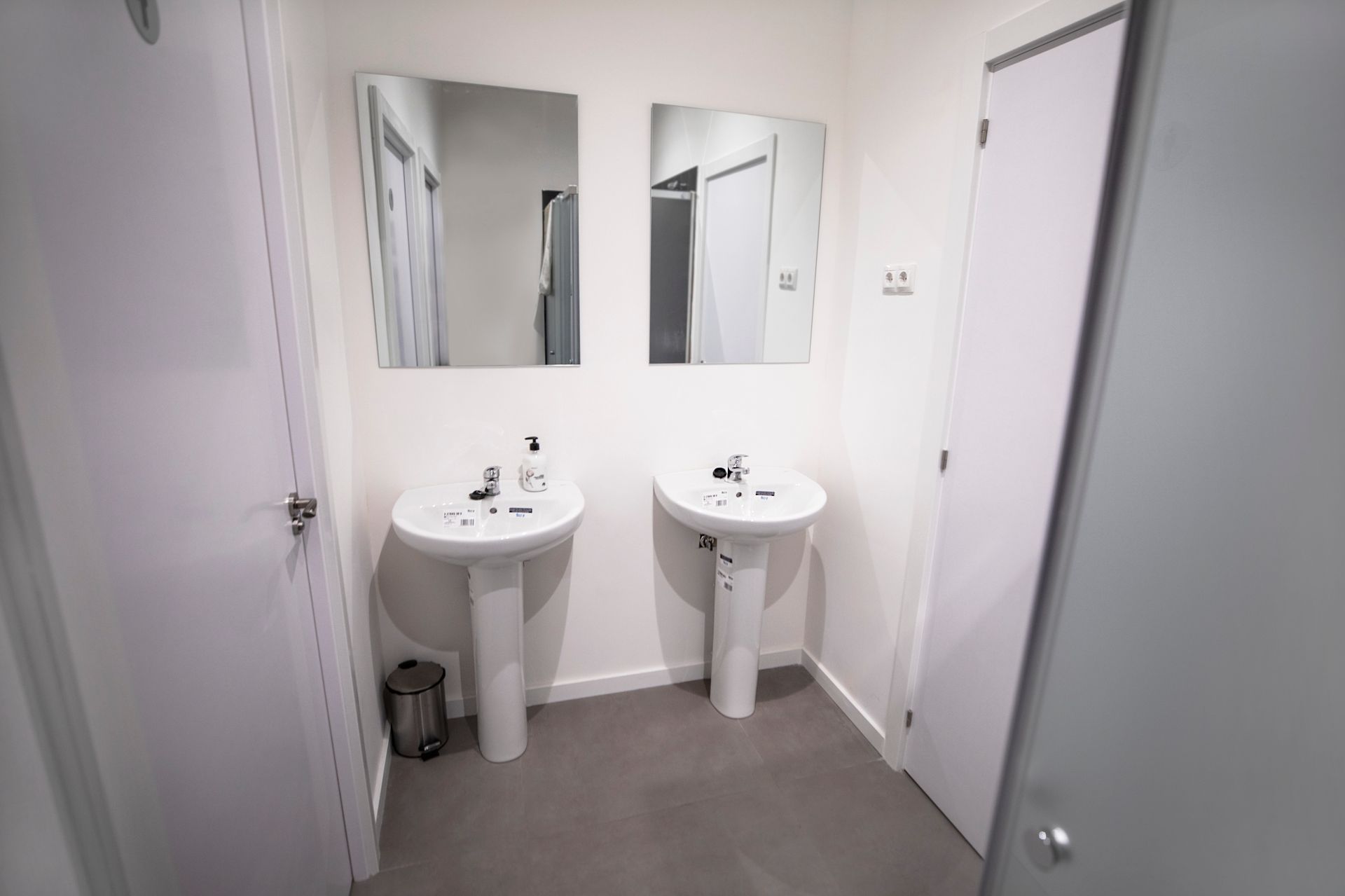 Un baño con dos lavabos y dos espejos.