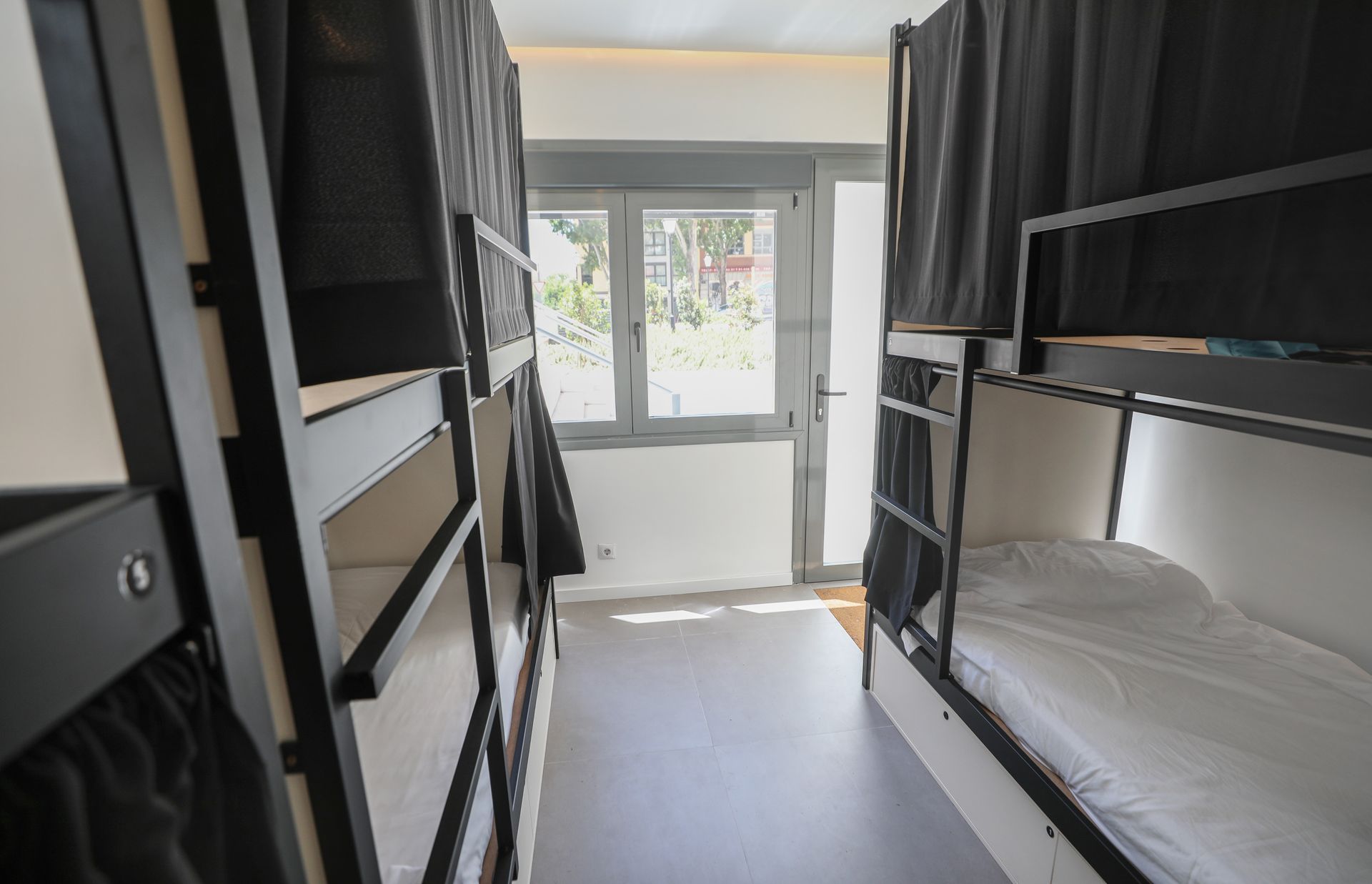 Una habitación con literas y una ventana en un albergue.