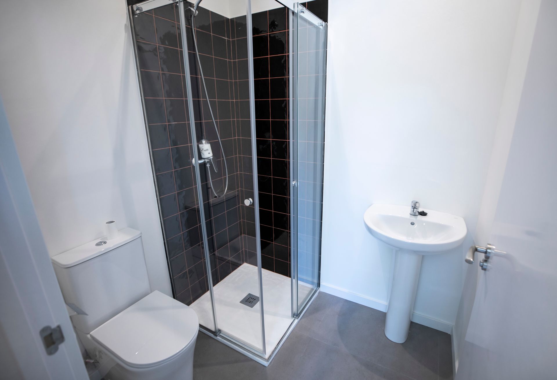 Un baño con inodoro, lavabo y ducha.