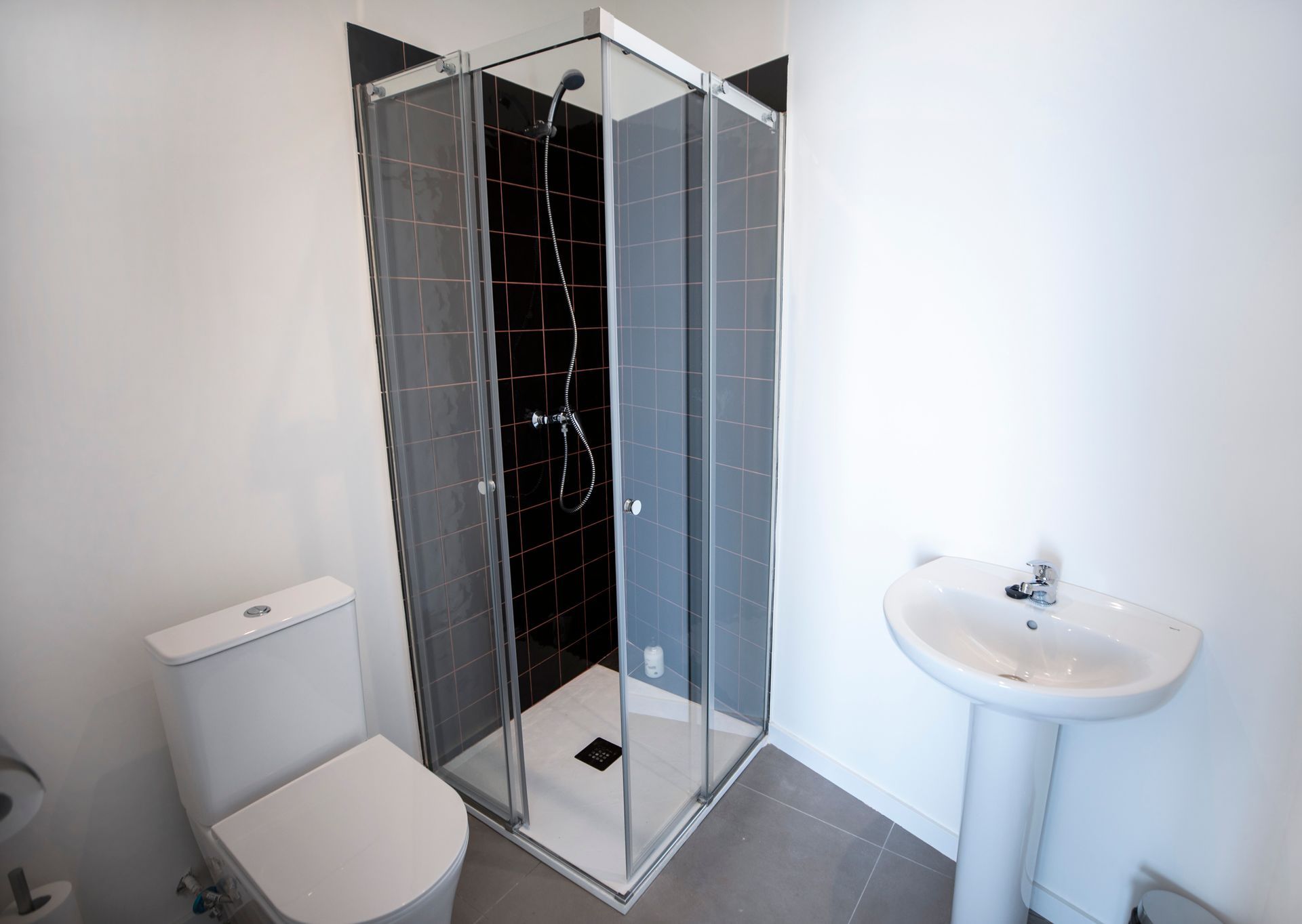 Un baño con inodoro, lavabo y ducha.