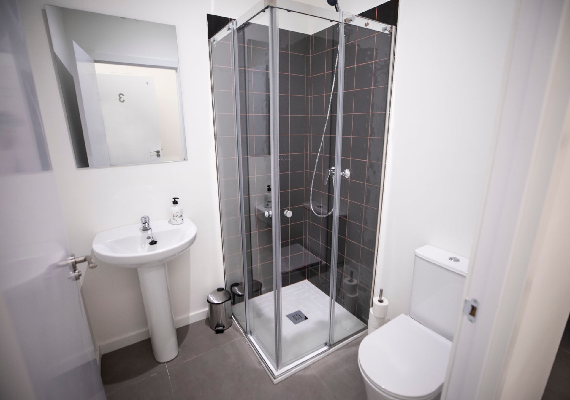Un baño con inodoro, lavabo y ducha.