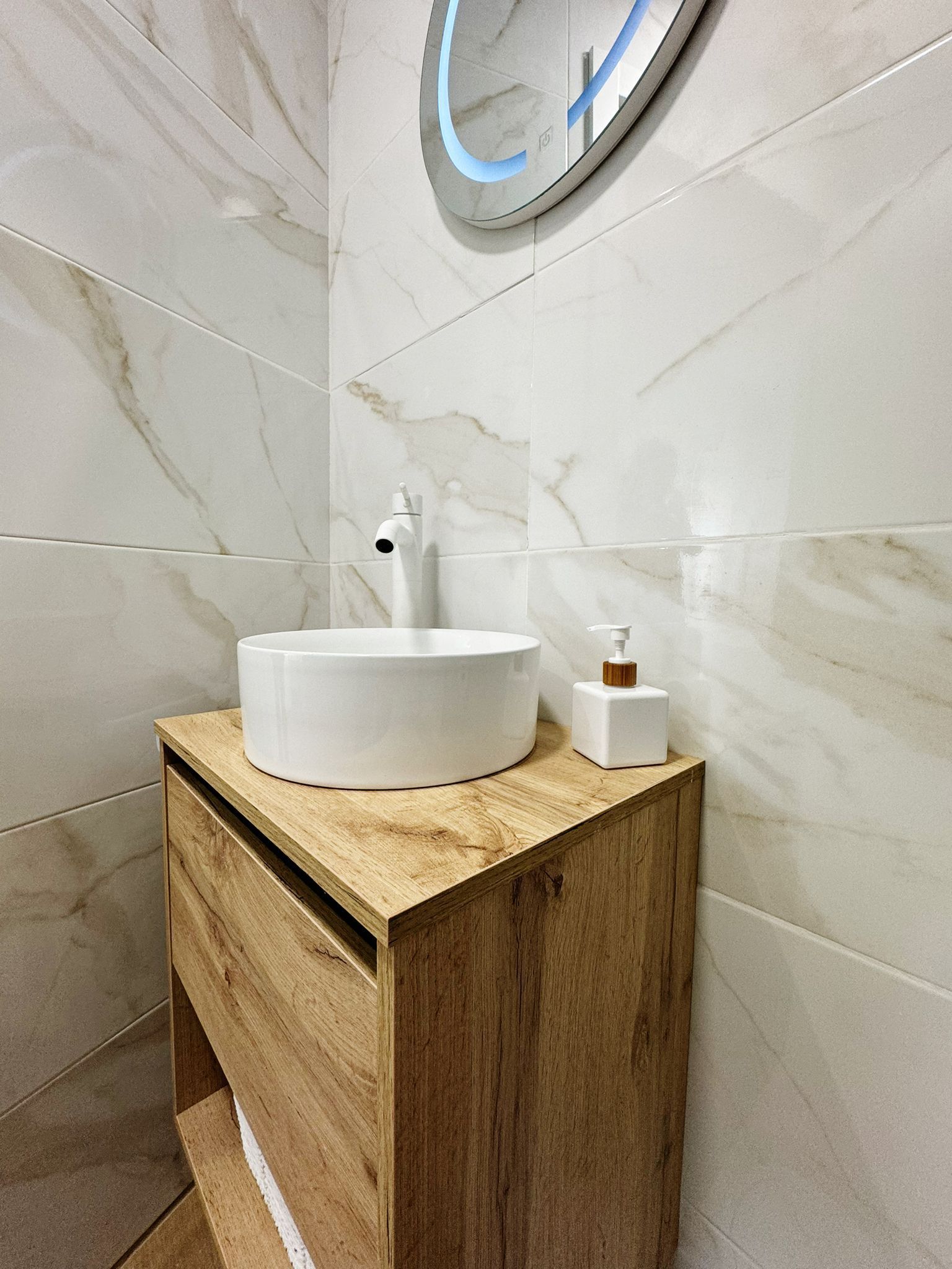 Un baño con un lavabo y un espejo en la pared.