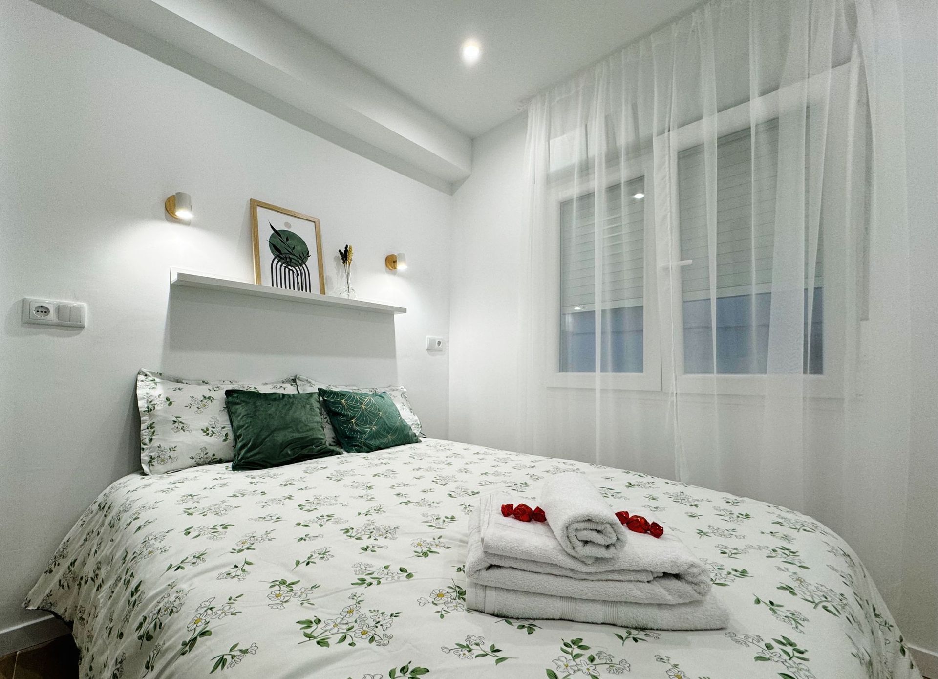 Un dormitorio con una cama y una ventana con cortinas.