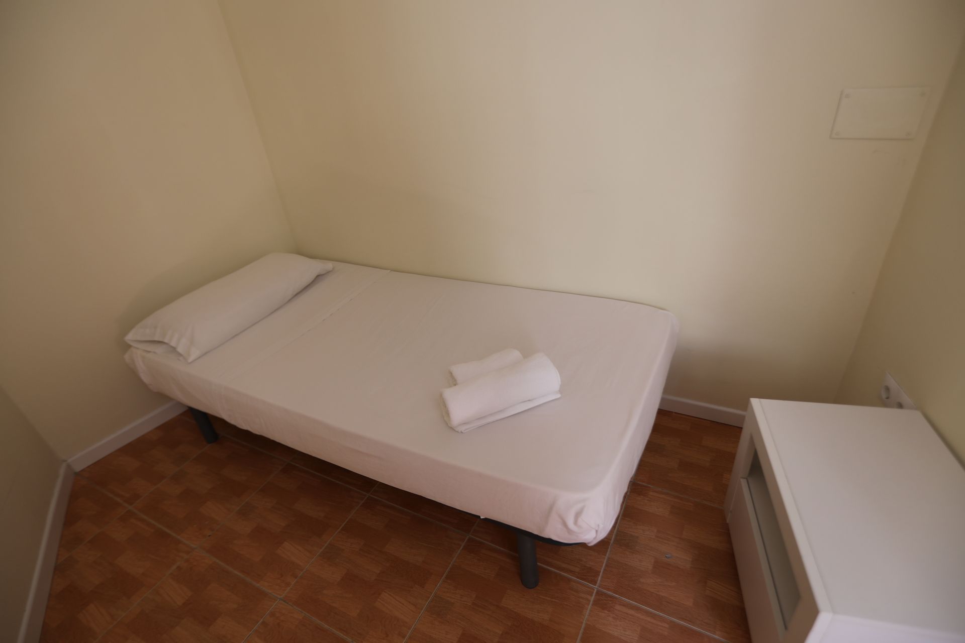 Un dormitorio pequeño con una cama individual y una mesita de noche.