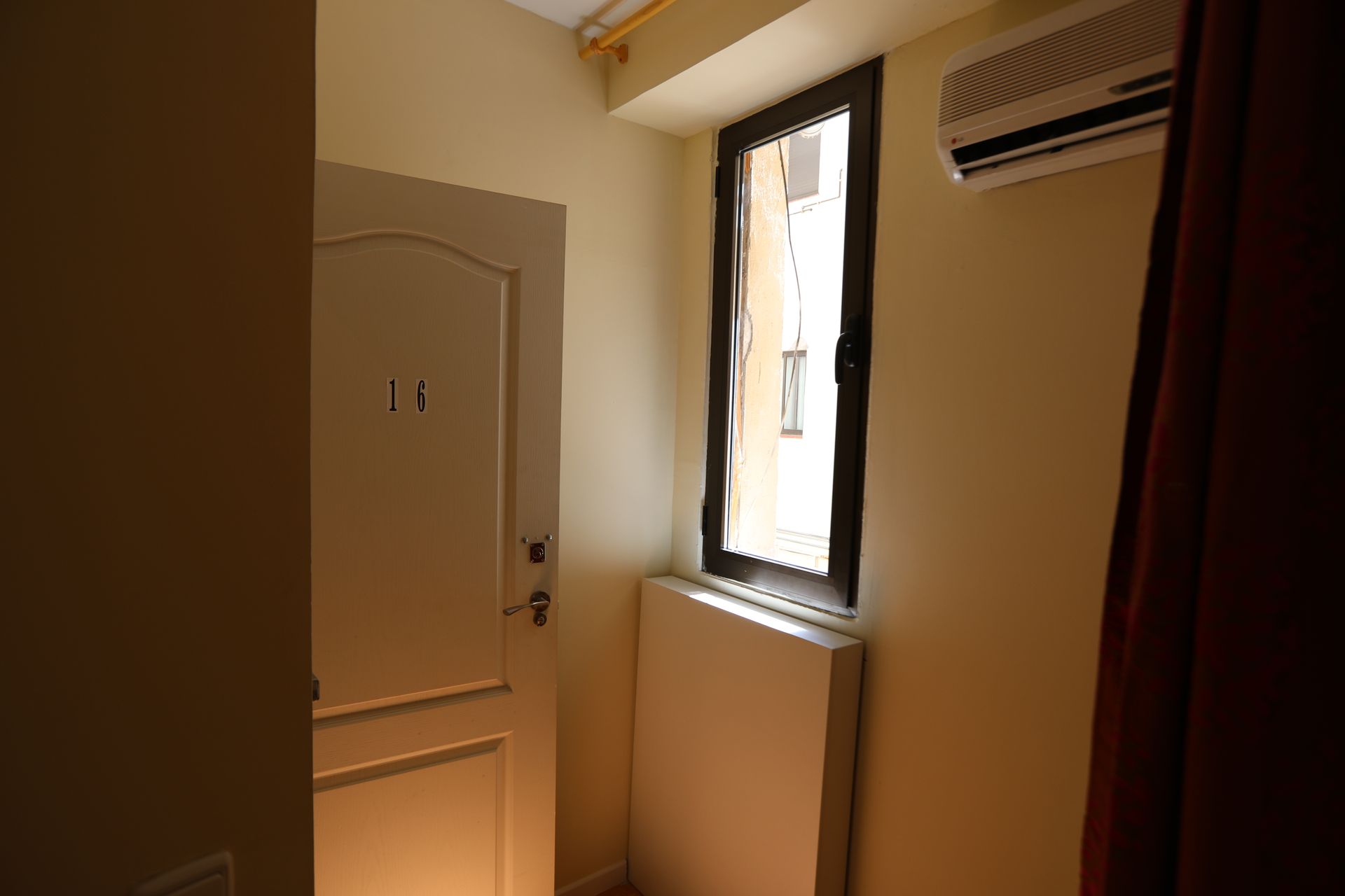 Una habitación con puerta, ventana y aire acondicionado.