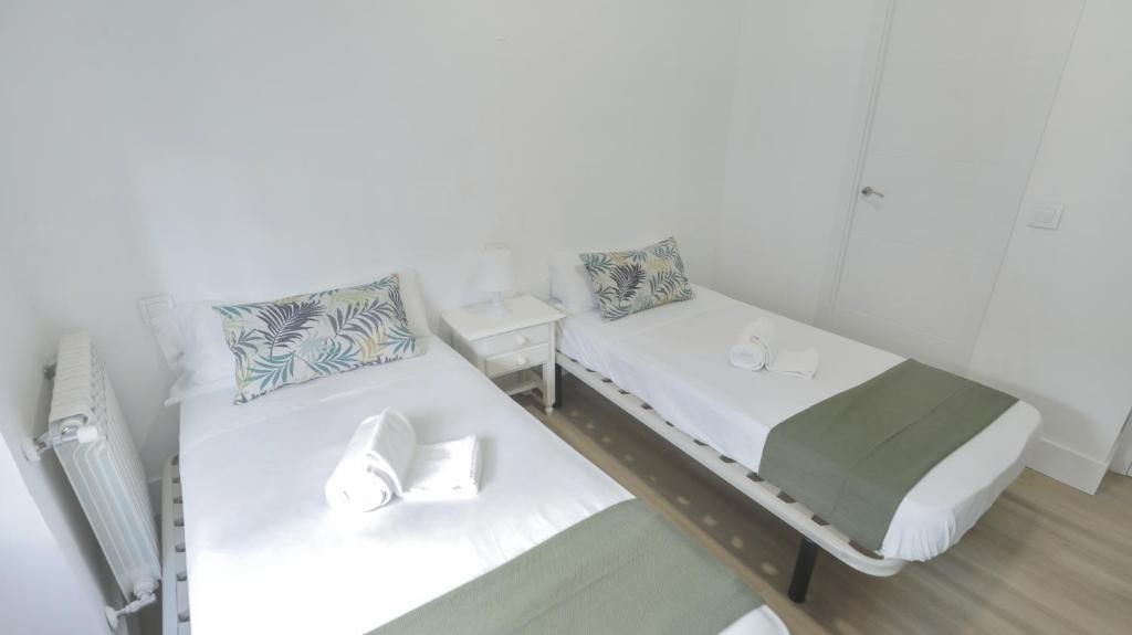 Un dormitorio con dos camas individuales y una mesita de noche.