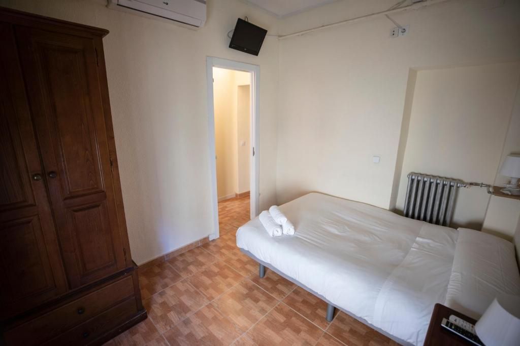 Un dormitorio con una cama, una cómoda y una televisión.