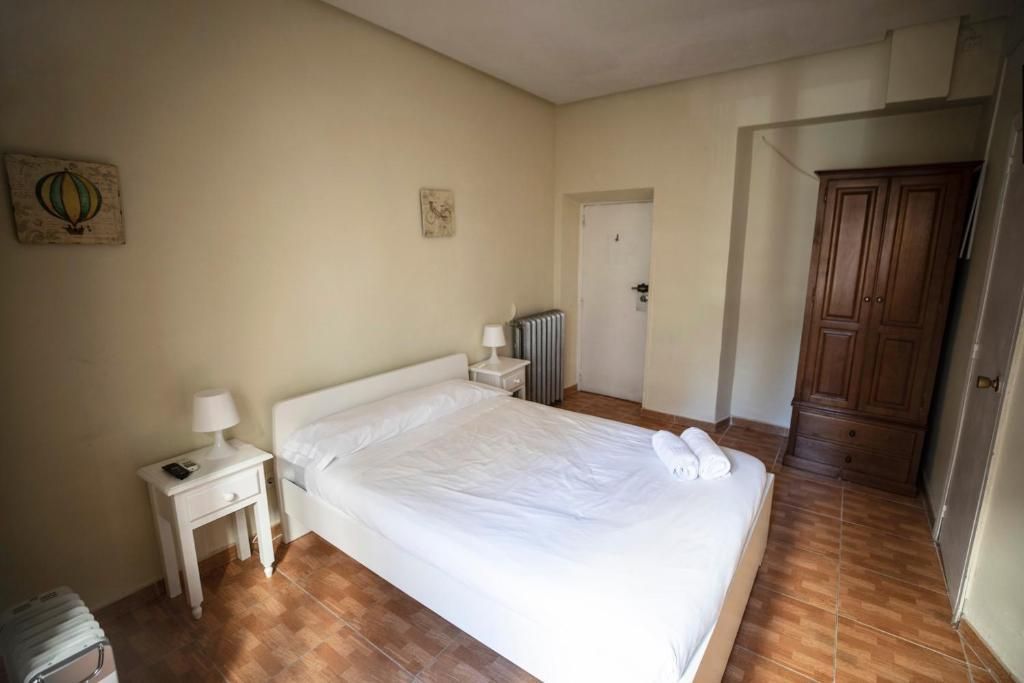 Un dormitorio con una cama, mesita de noche y armario.