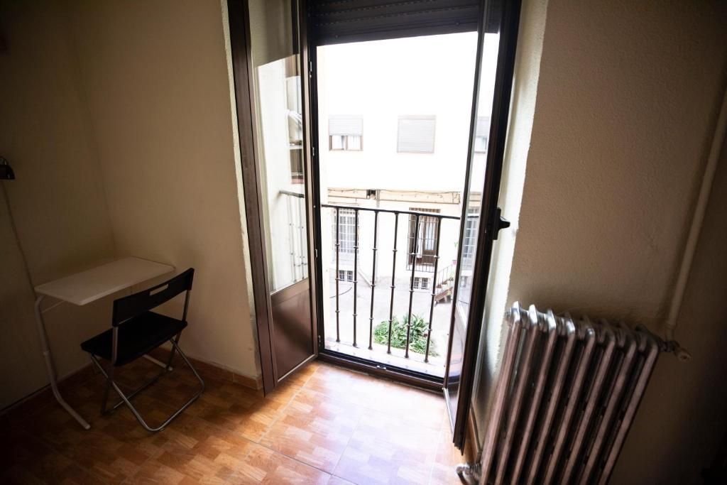 Una habitación vacía con una mesa y sillas y un radiador.