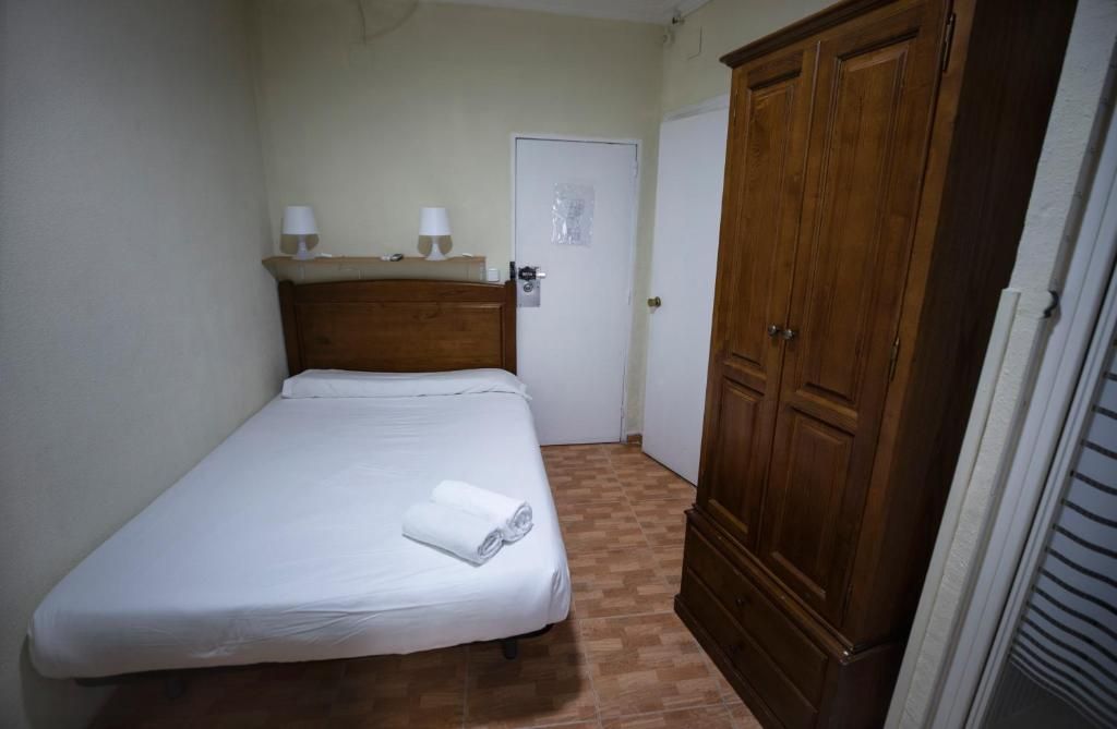 Un dormitorio con una cama, un armario y una puerta.