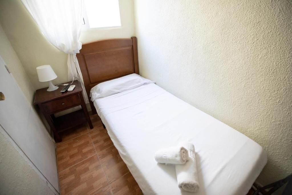 Un dormitorio pequeño con una cama individual y una mesita de noche.