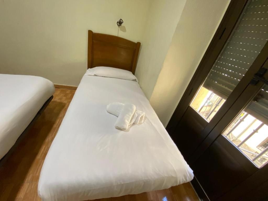 Un dormitorio con dos camas y una ventana con persianas.