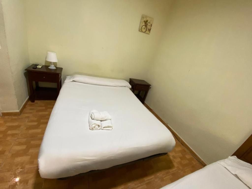 Un dormitorio con una cama individual y dos mesitas de noche.