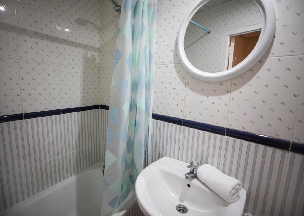 Un baño con lavabo, bañera, ducha y espejo.