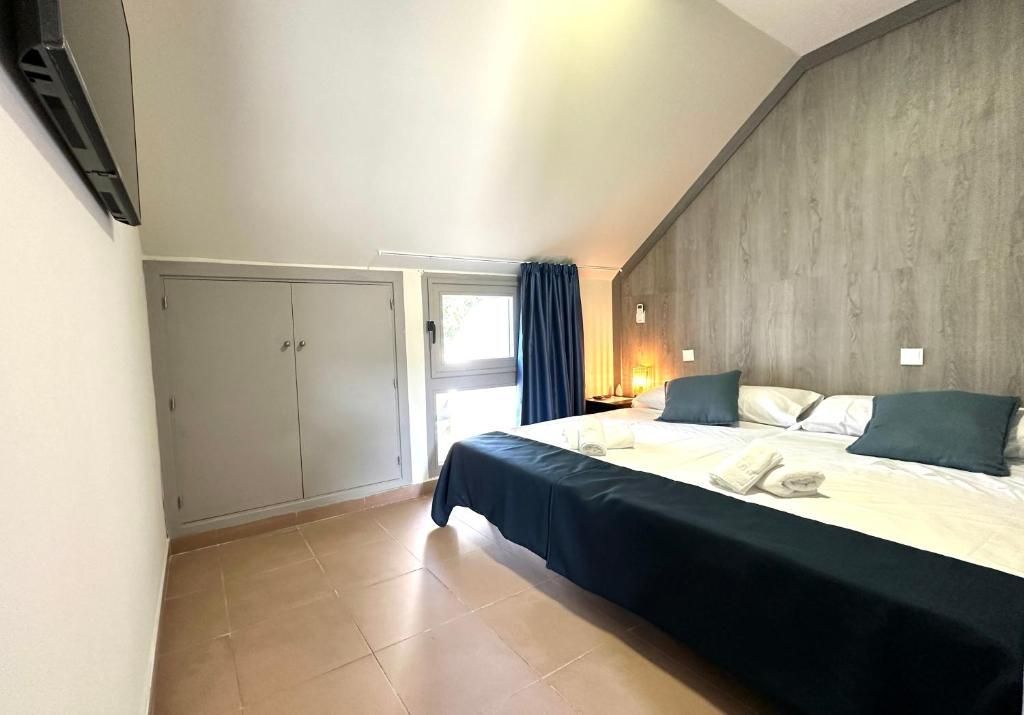 Un dormitorio con una cama grande y un televisor de pantalla plana.