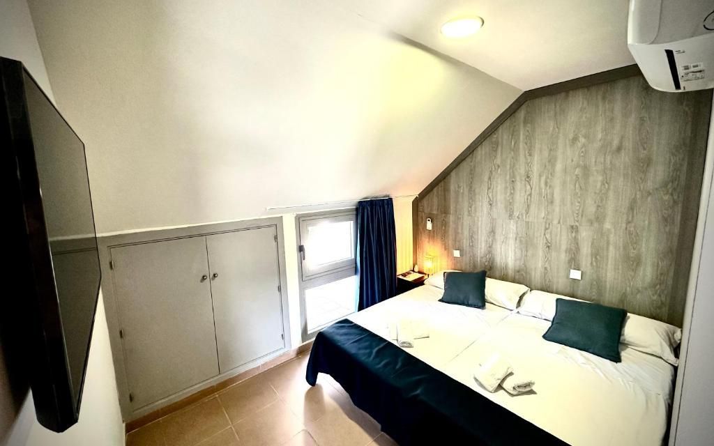 Un dormitorio con una cama king size y un televisor de pantalla plana.