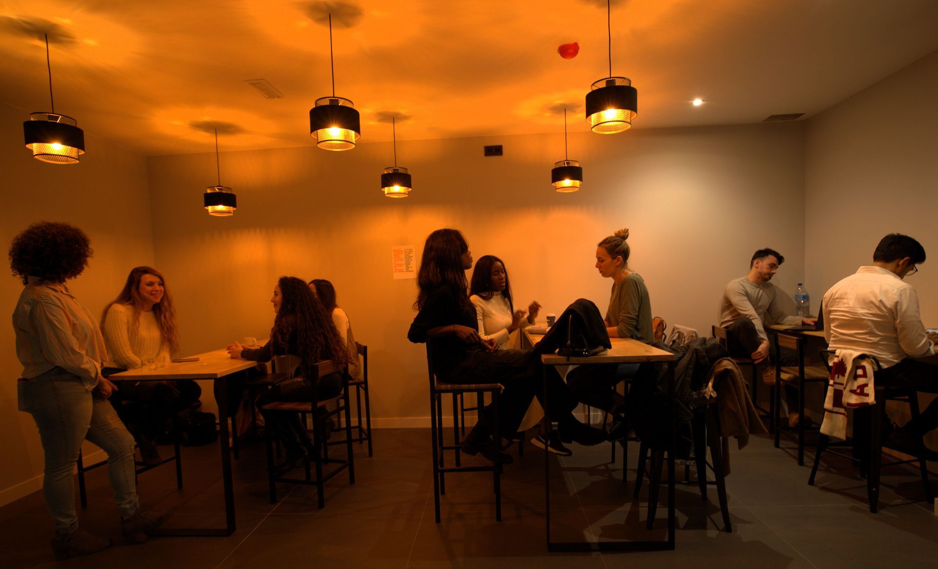 Un grupo de personas están sentadas en mesas en un restaurante.