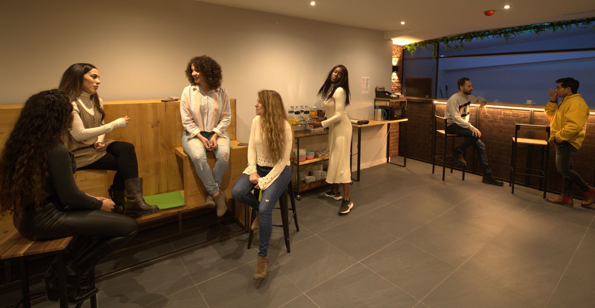 Un grupo de personas están sentadas y de pie en una habitación.