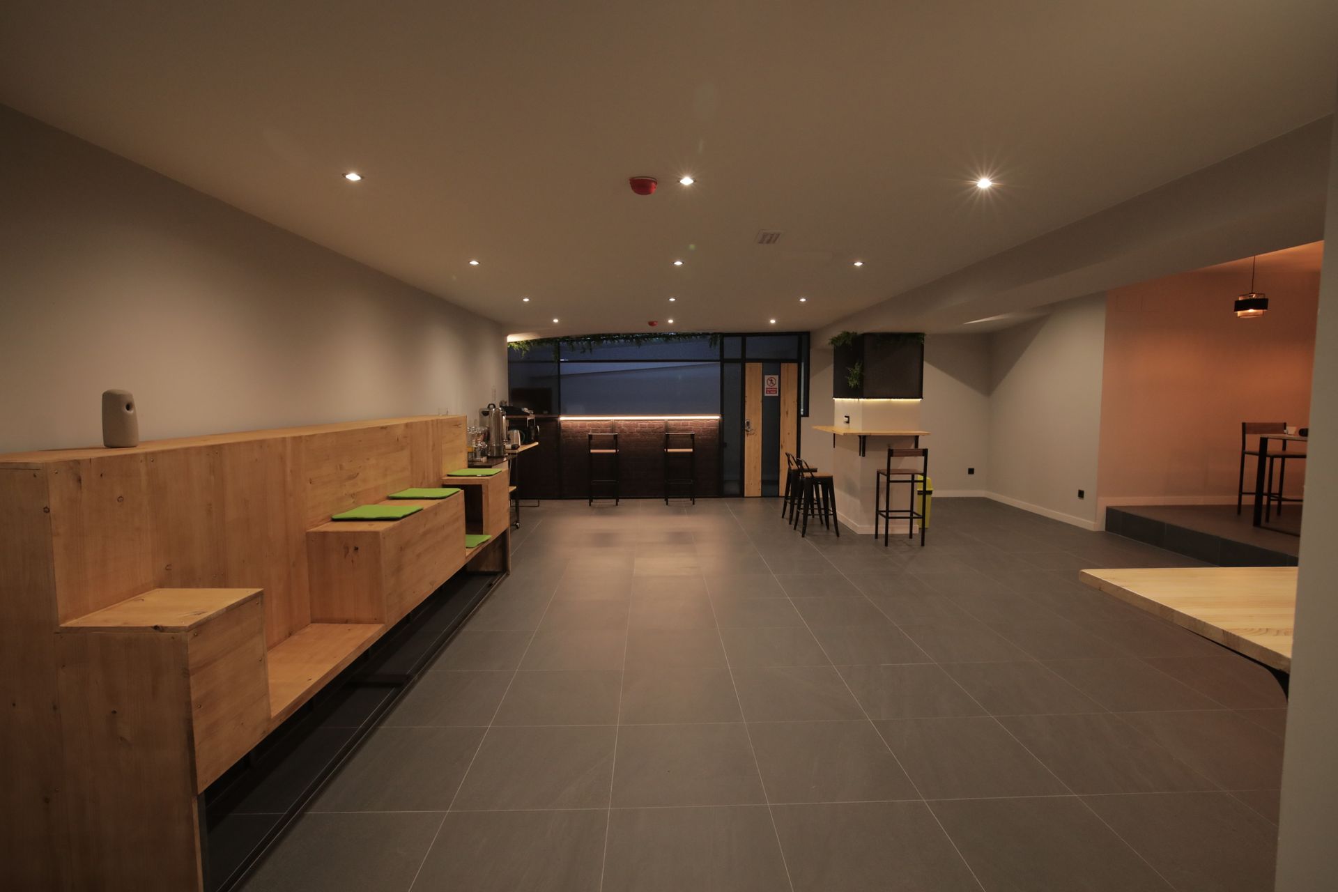 Una gran habitación vacía con un banco de madera y mesas.