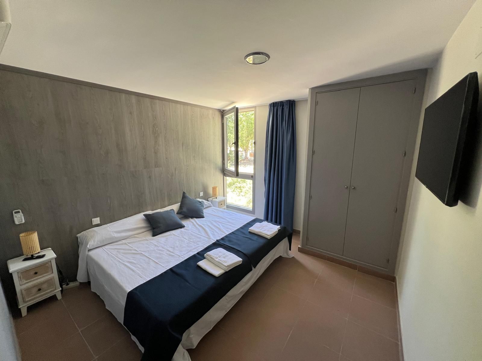 Un dormitorio con una cama grande y un televisor de pantalla plana.