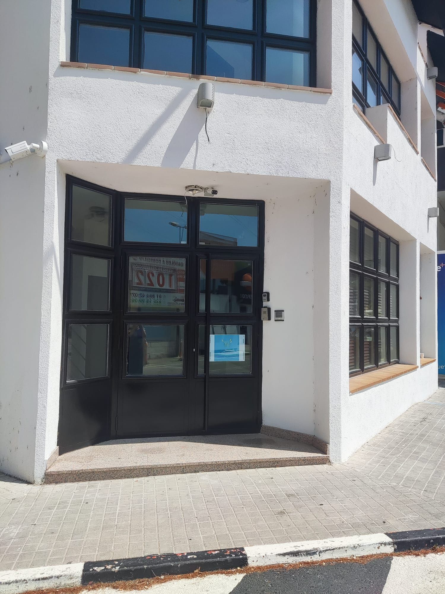 Un edificio blanco con una puerta y ventanas negras