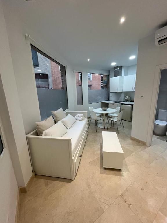 Una sala de estar con sofá, mesa y sillas.