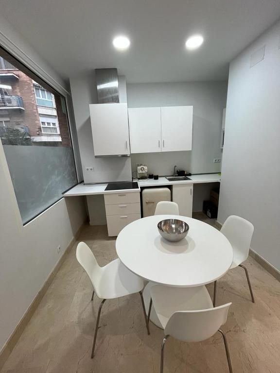 Una cocina con una mesa redonda y cuatro sillas.