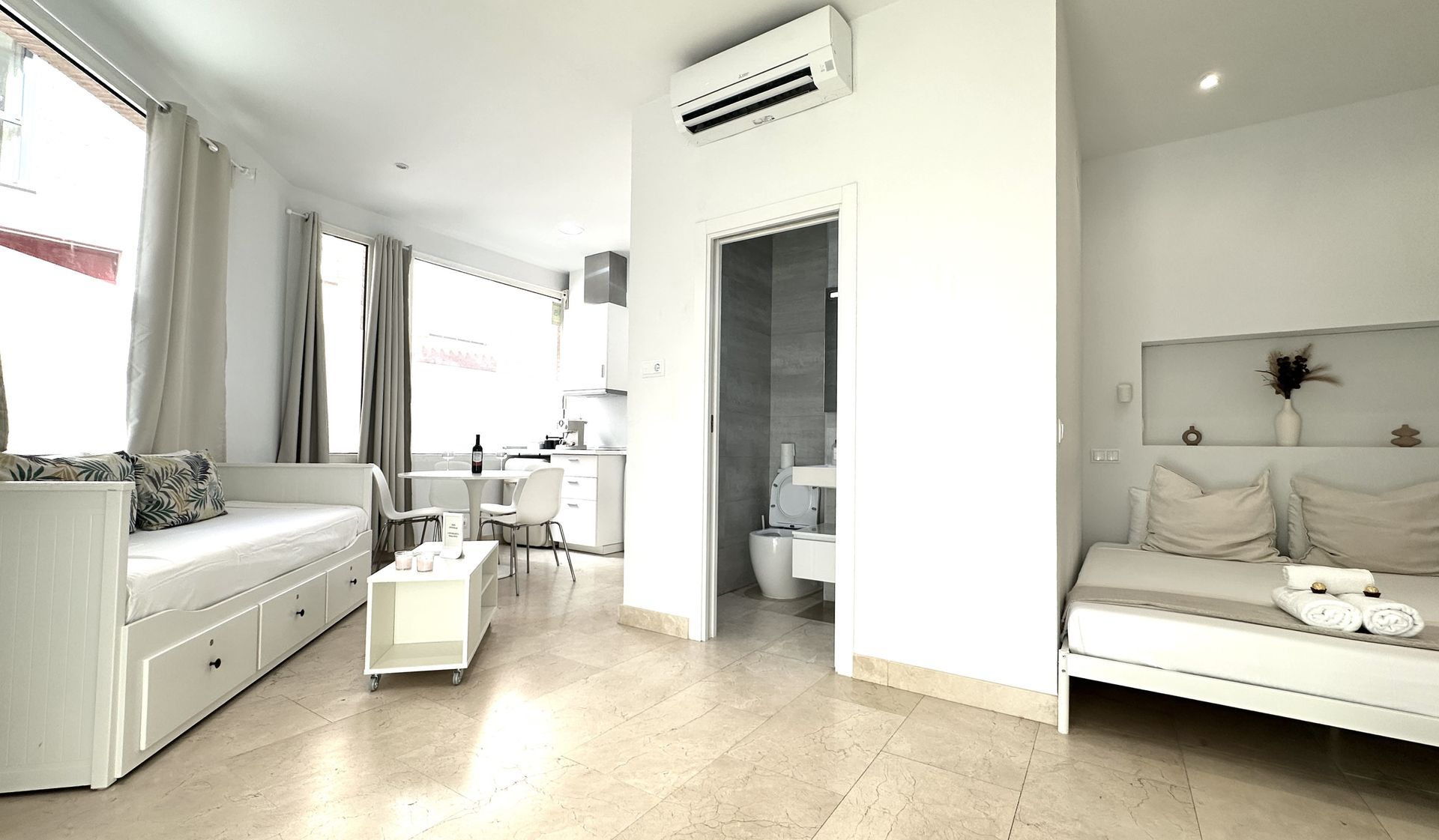 Una sala de estar blanca con un sofá y una mesa.