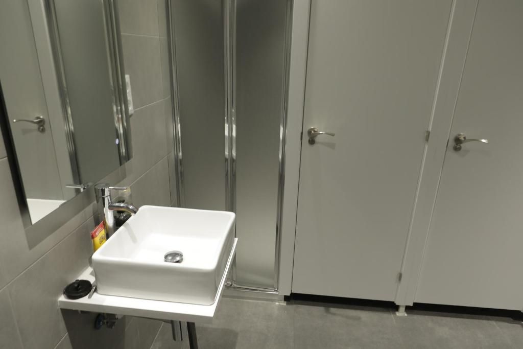 Un baño con lavabo, espejo y ducha.