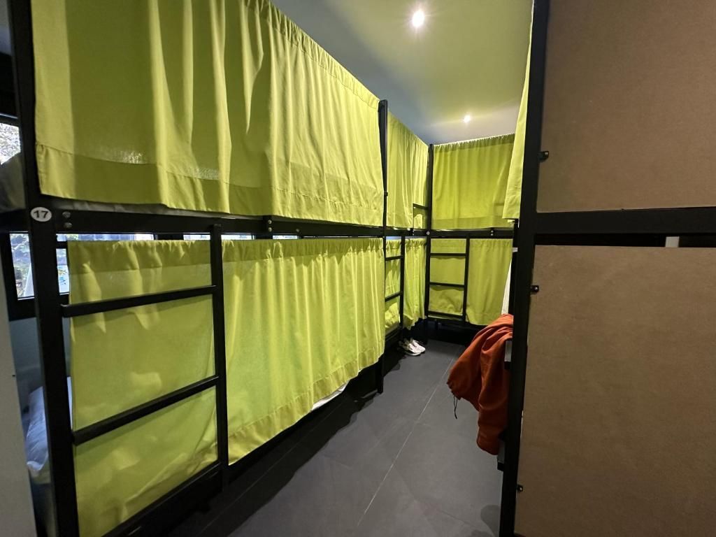 Una fila de literas con cortinas amarillas en una habitación.