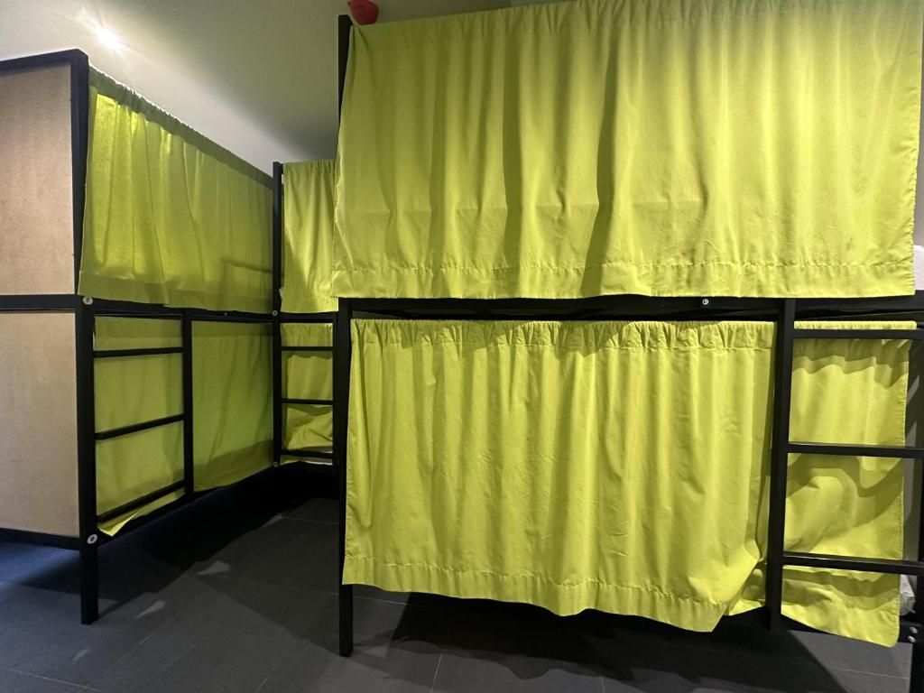 Una fila de literas con cortinas amarillas en un dormitorio.