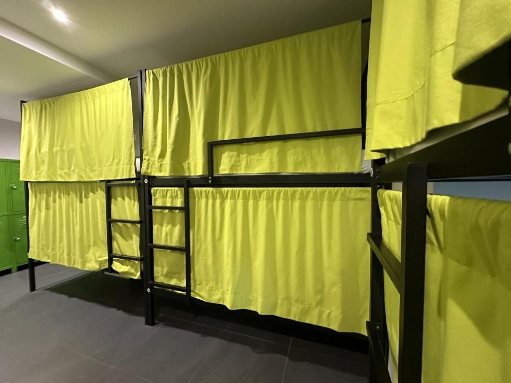 Una litera con cortinas amarillas y una escalera en un dormitorio.
