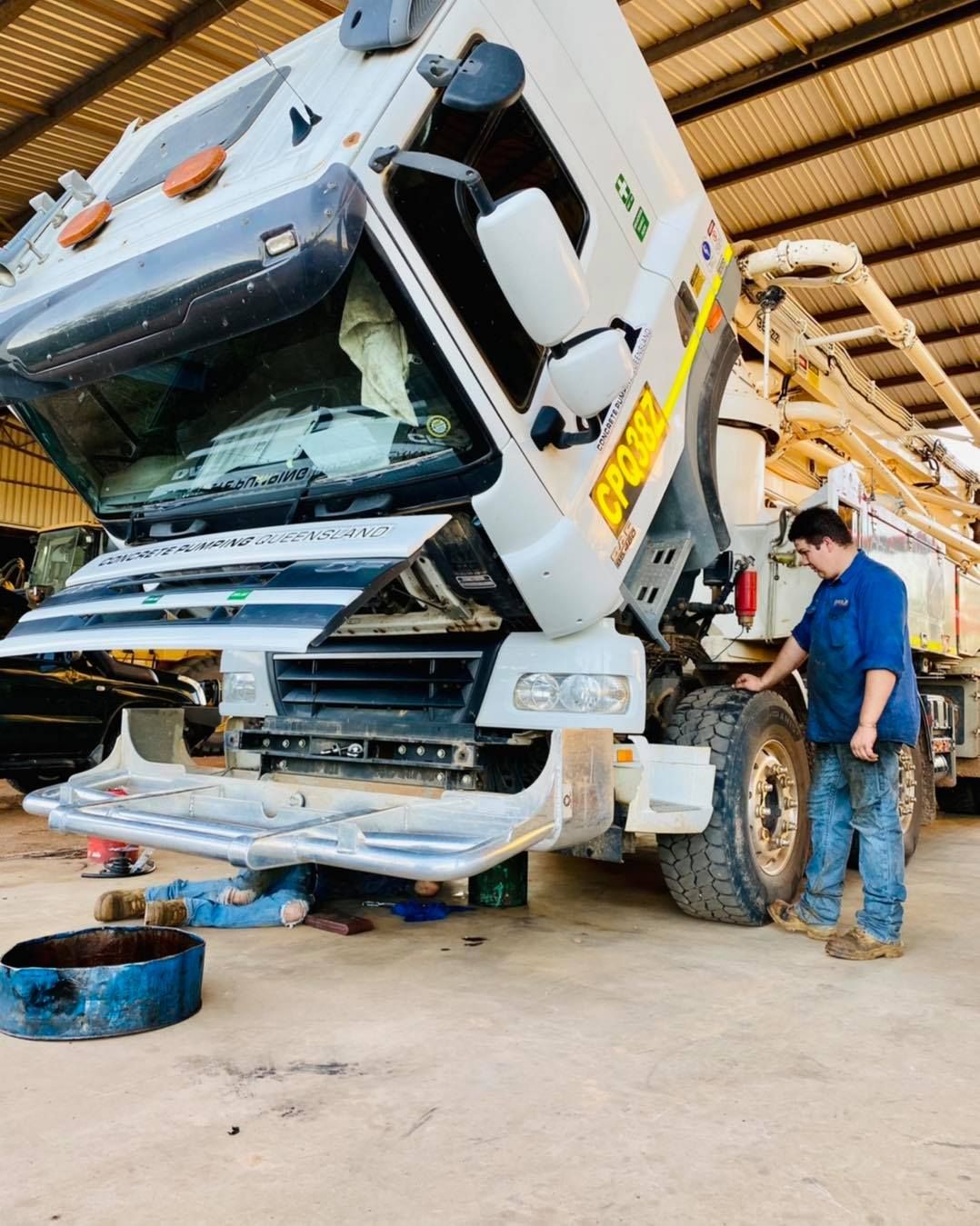 Mechanic Working on a Large White Truck With Its Hood Open — Traction Diesel Services in Clermont, QLD