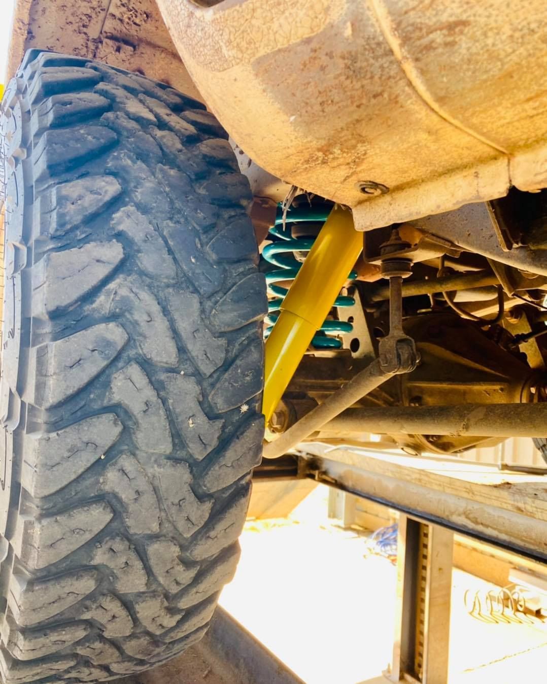 Close-up of a Vehicle's Tire, Suspension, and Yellow Shock Absorber — Traction Diesel Services in Clermont, QLD