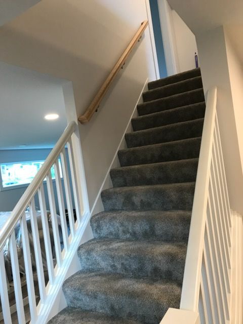 Carpeted staircase with white railing and beige walls in a home interior