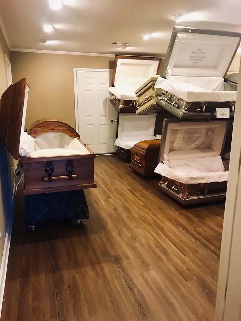 Room with open coffins, a display area at a funeral home.