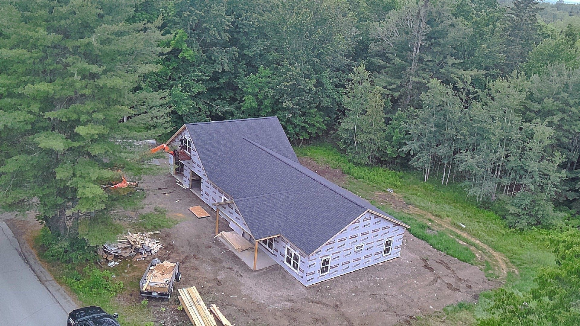 drone photo of new construction home new roof install in Maine