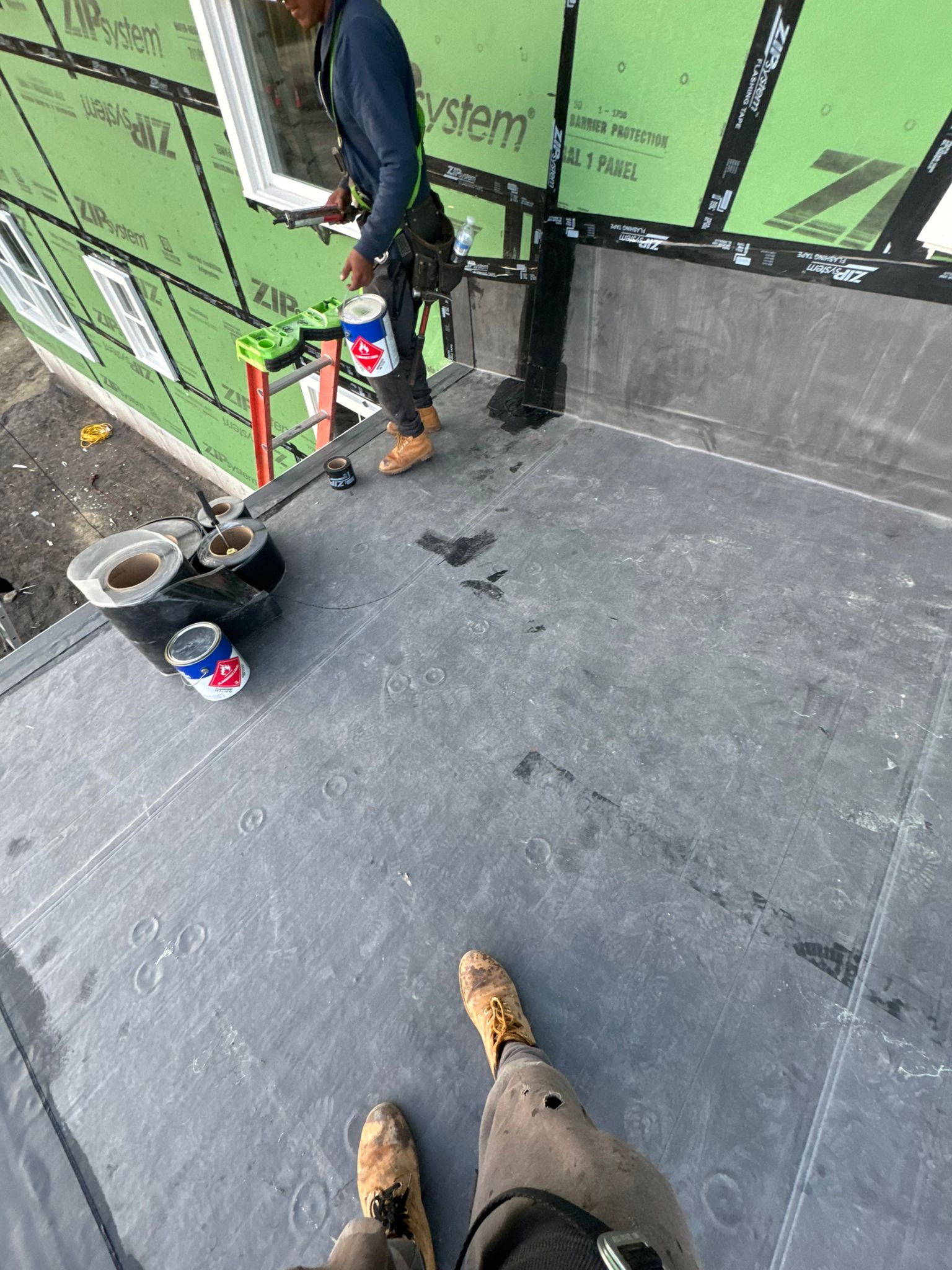 EPDM TPO rubber roof installations showing a worker on the roof MJJ roofing and siding