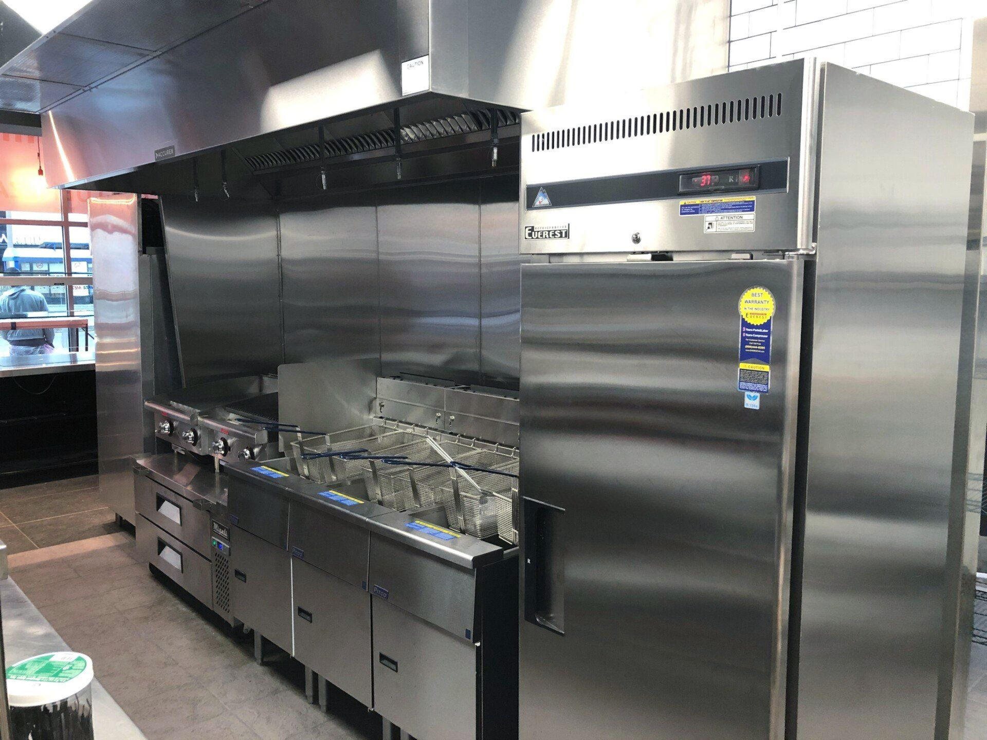 a stainless steel refrigerator, fryer, and stove