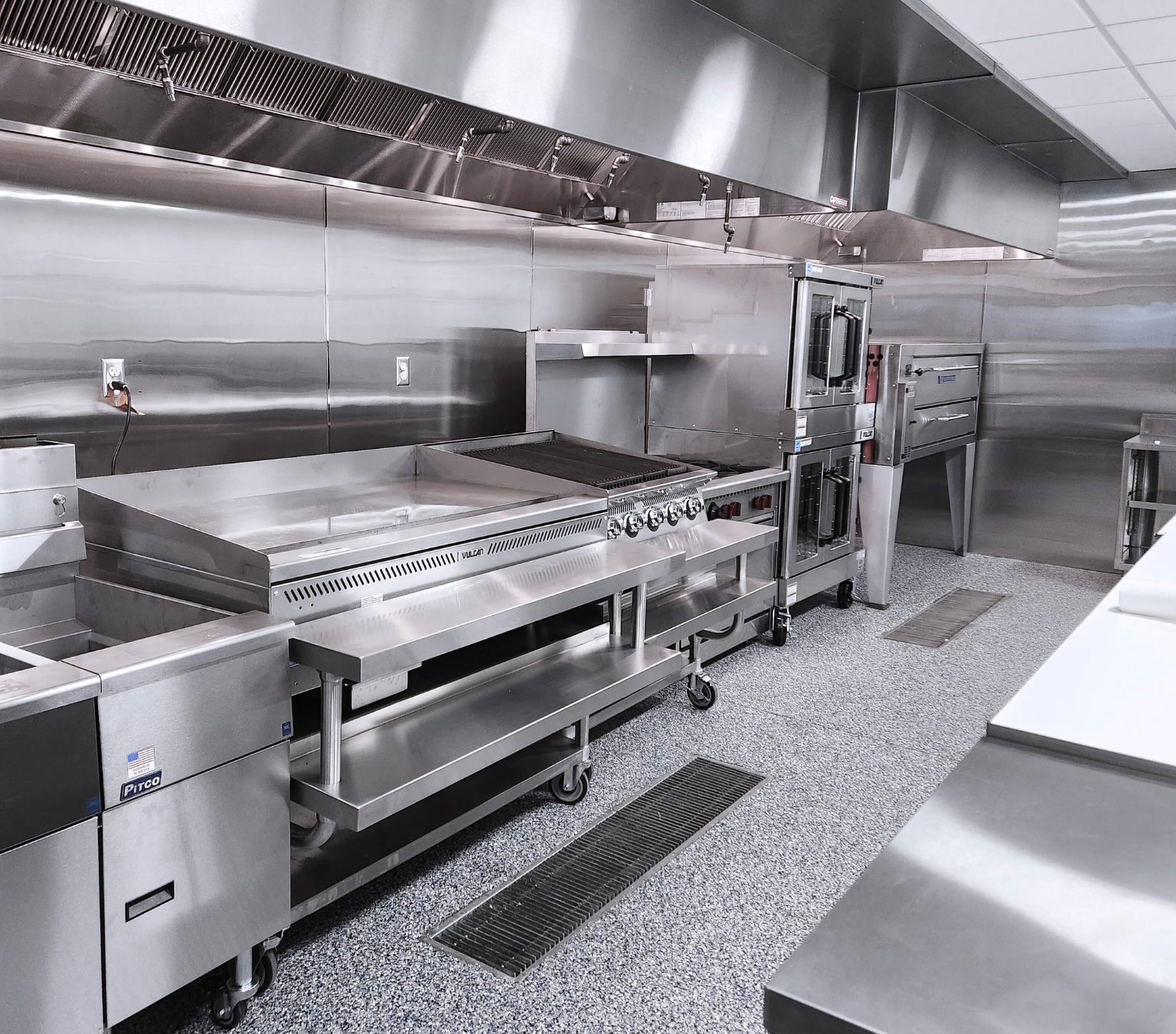 a stainless steel pizza oven is stacked on top of each other in a room .