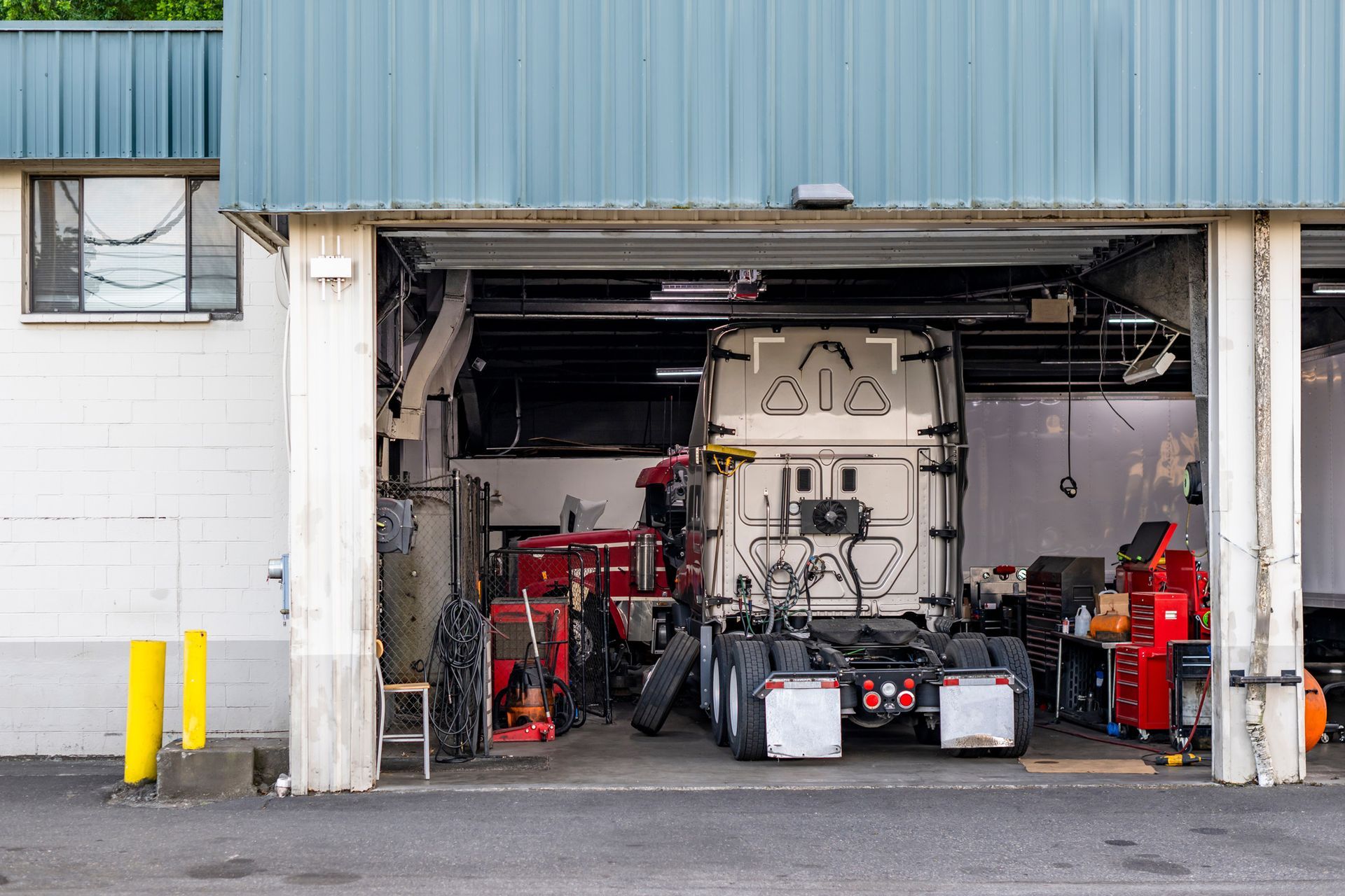 Open garage with industrial equipment, tools, and machinery inside