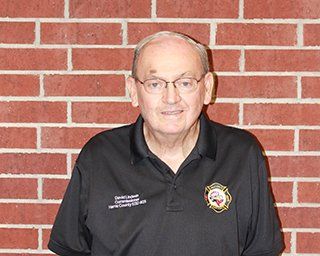 A picture of Commissioner David Lindeen wearing glasses and a black shirt with a HCESD25 logo patch.