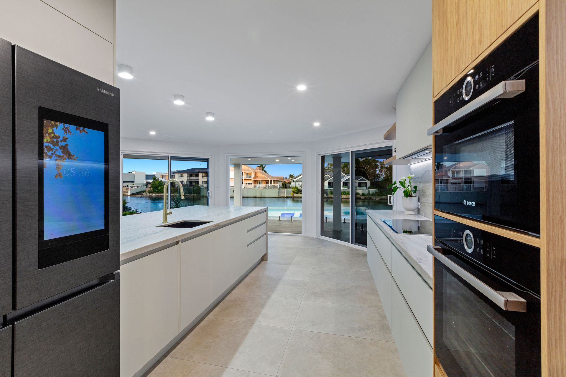A Kitchen With White Cabinets and a Large Island in the Middle — Truline Cabinets In Nambour, QLD