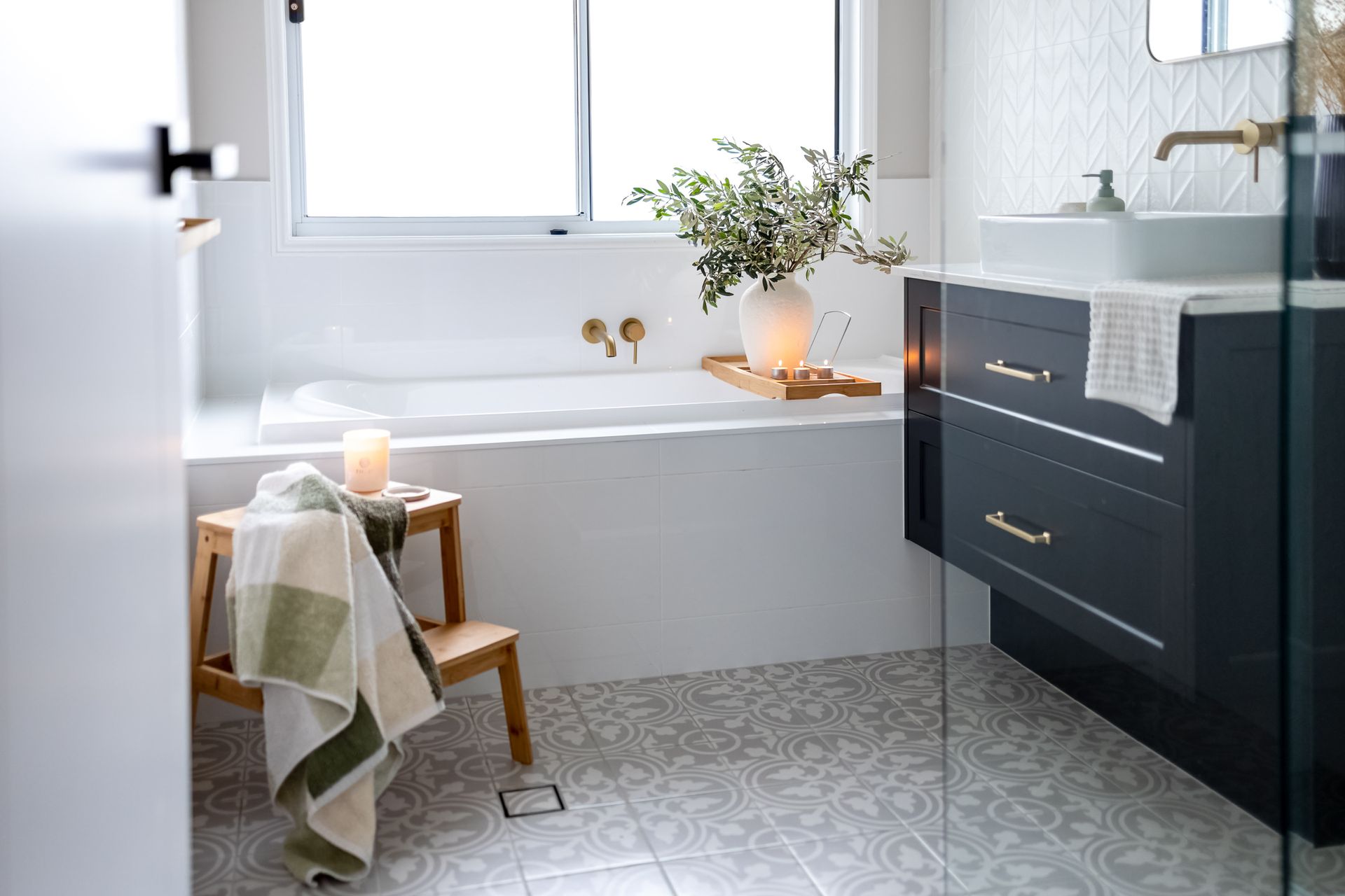 A Bathroom With a Tub, Sink and Mirror — Truline Cabinets In Nambour, QLD