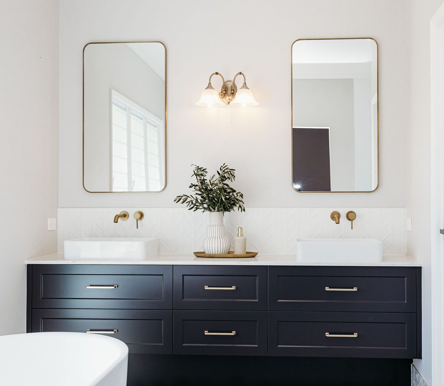 A Bathroom With a Tub, Sink and Mirror — Truline Cabinets In Tuchekoi, QLD