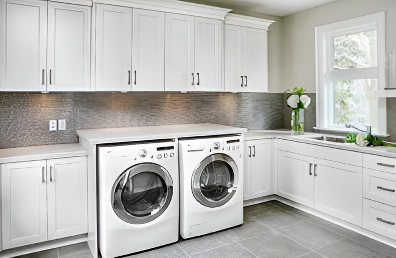 A Laundry Room With a Washer and Dryer and White Cabinets — Truline Cabinets In Tuchekoi, QLD