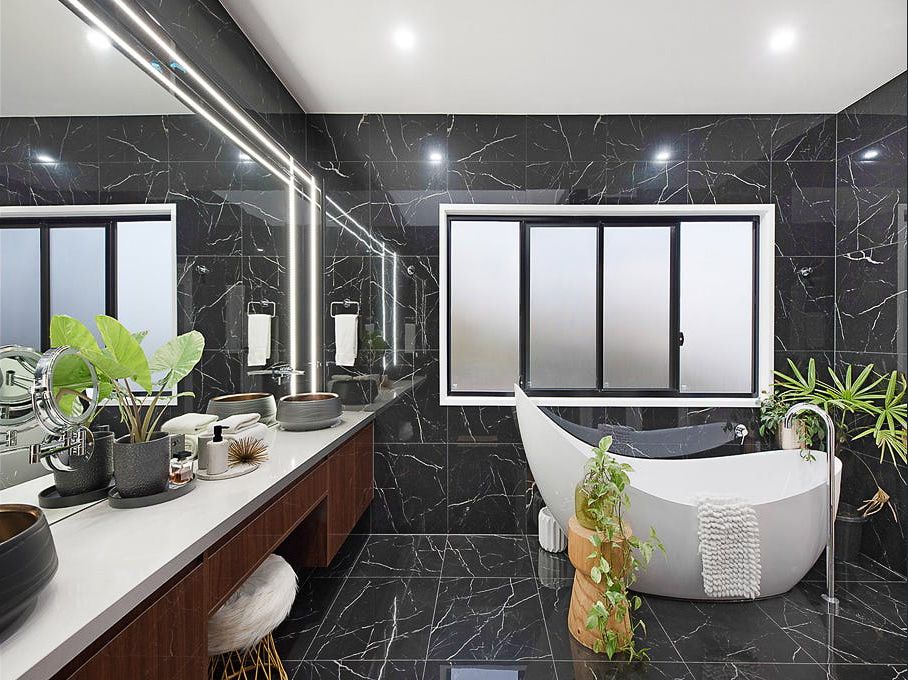 A Bathroom With a Tub, Sink and Mirror — Truline Cabinets In Cooroy, QLD