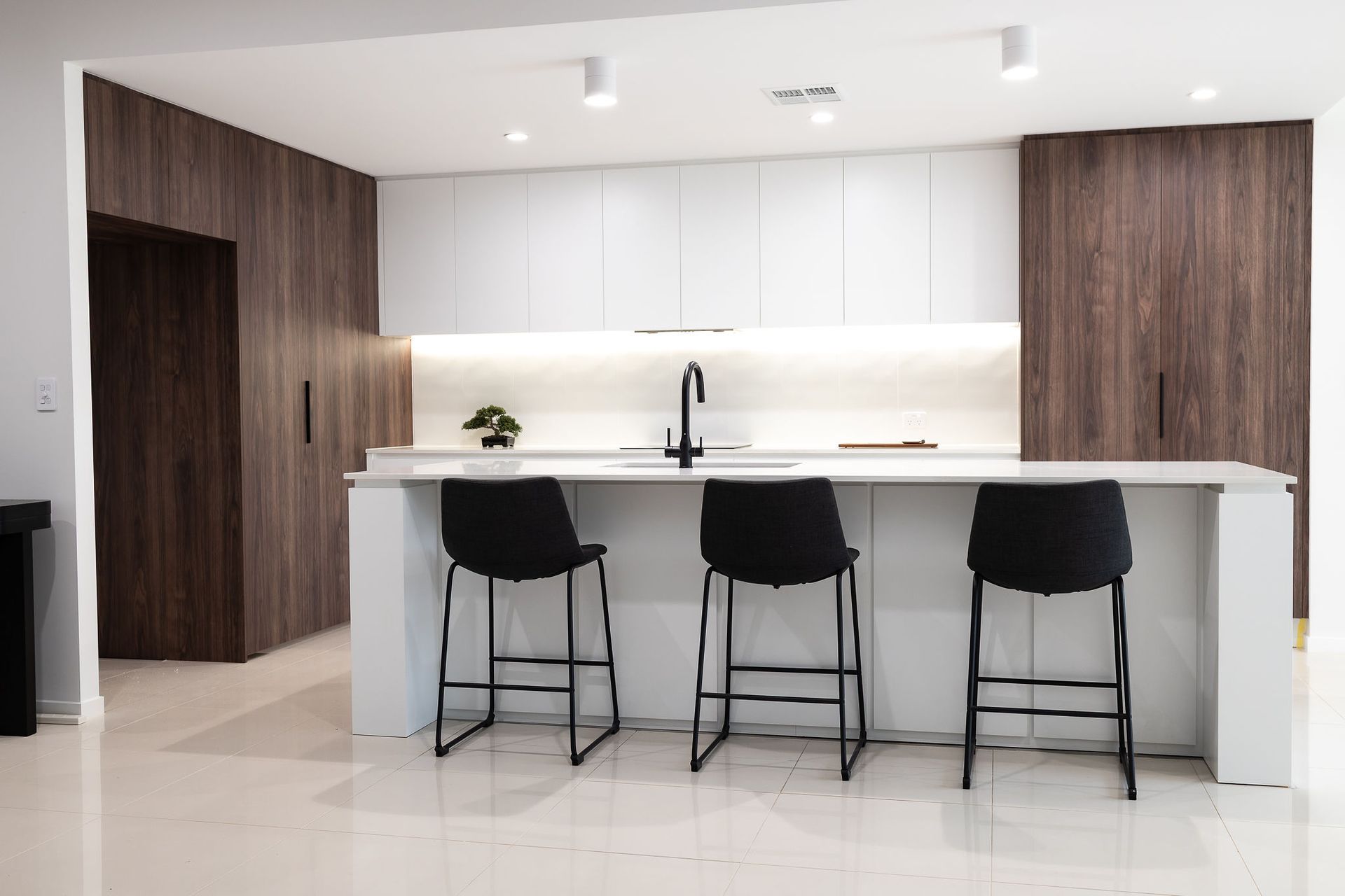 Modern Kitchen With White and Wood Cabinets, Island With Three Black Stools — Truline Cabinets In Tuchekoi, QLD